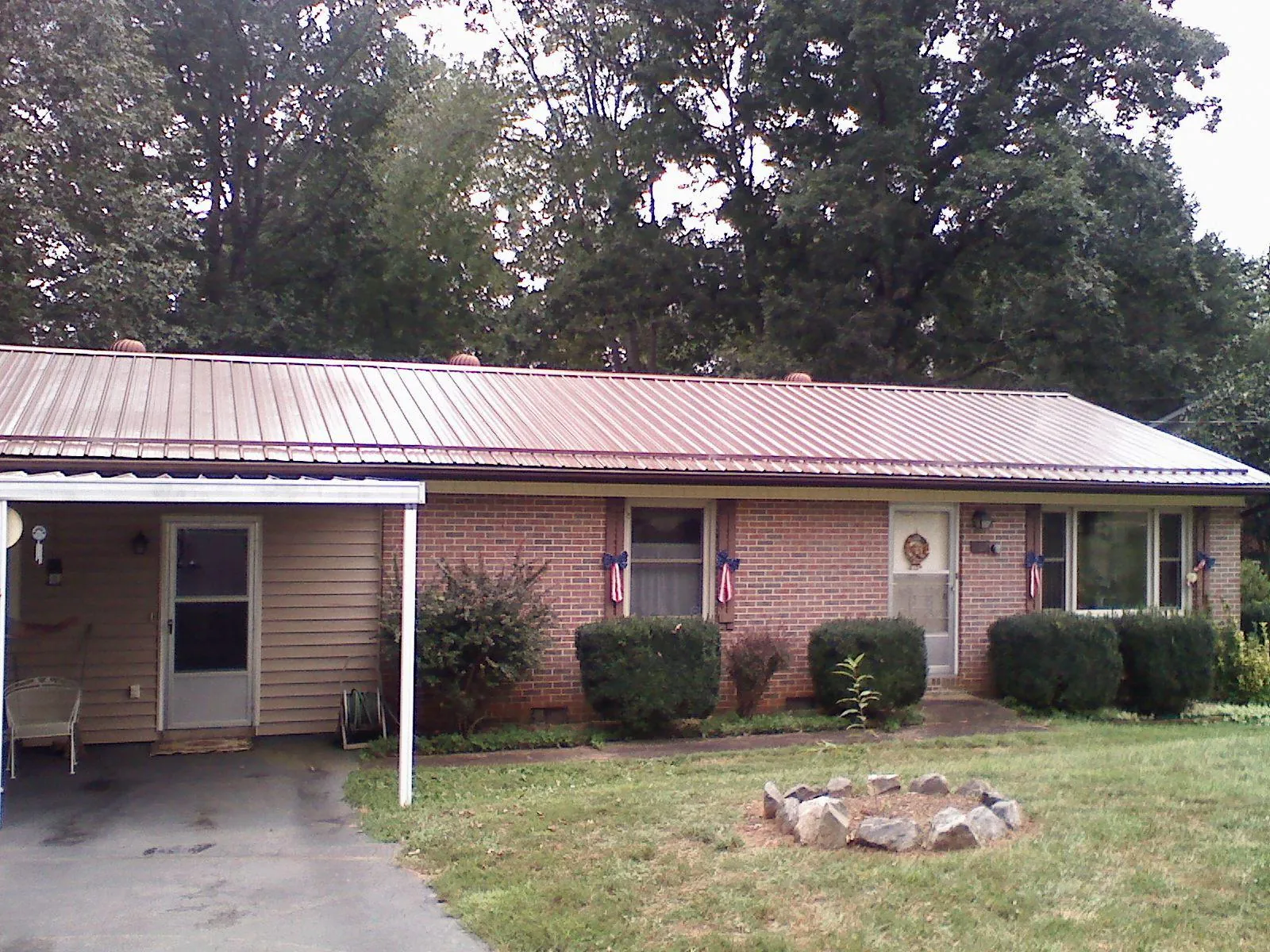 Bronze metal roof and carport on a brick ranch home — Roof Repair work by our crew in Grand Blanc