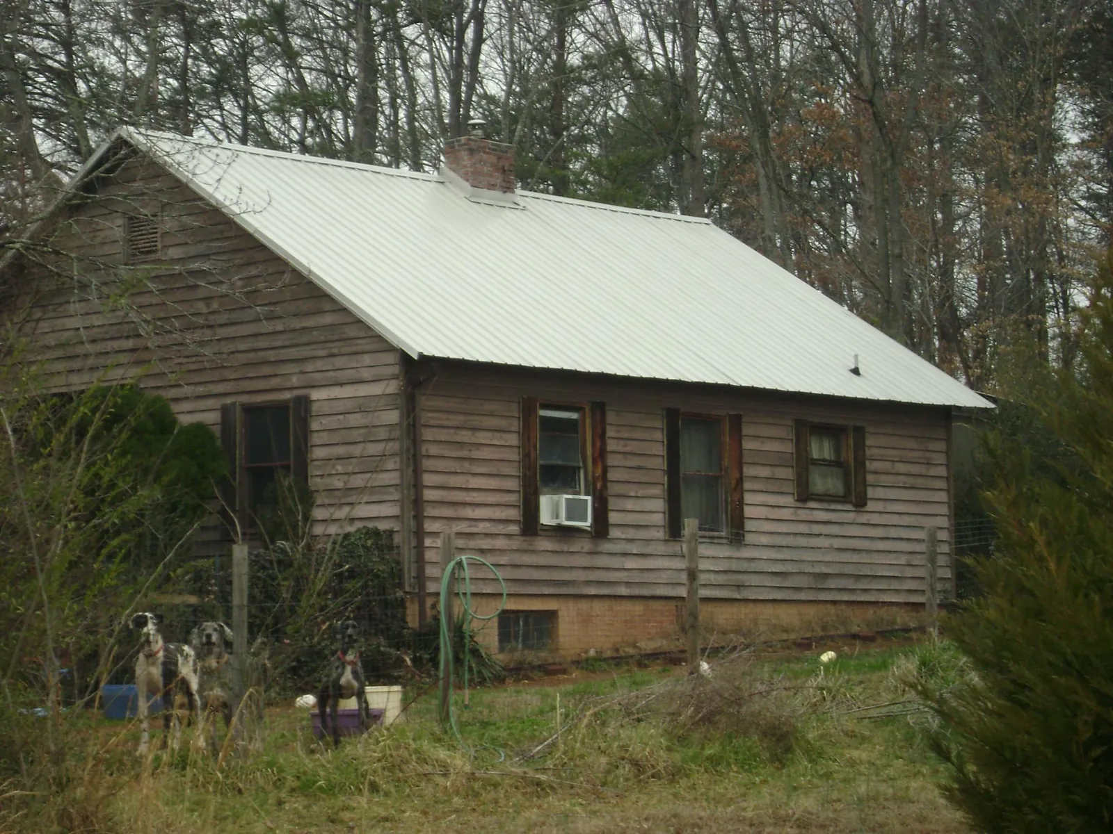 White metal roof on an old wood sided farmhouse, from a Metal Roof Installation job in Grand Blanc